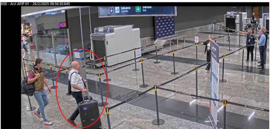<b>Uno de los tripulantes del avi&oacute;n es dirigido por un agente aduanero para evitar el control de valijas. (Foto: TN).</b>